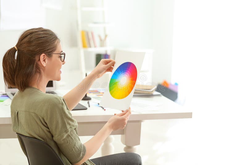 Diseñador joven hermoso que trabaja con la paleta de colores en oficina foto de archivo Diseñador joven hermoso que trabaja con la paleta de colores en oficina foto de archivo