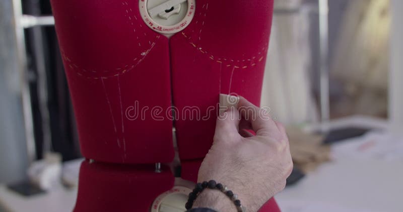 Diseñadores masculinos cercanos dibujan mano maniquí con una línea punteada en un atelier de vestidos almacen de metraje de vídeo