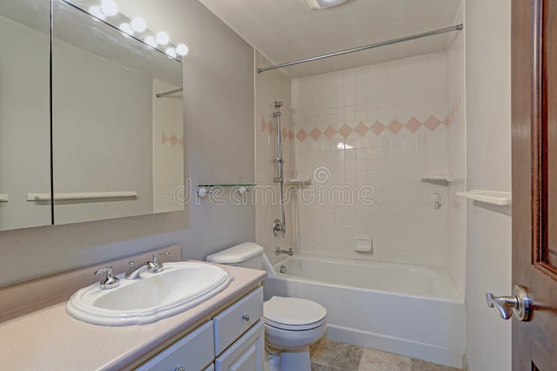 Diseño blanco del cuarto de baño con el gabinete y la tina de la vanidad fotografía de archivo libre de regalías Diseño blanco del cuarto de baño con el gabinete y la tina de la vanidad fotografía de archivo libre de regalías