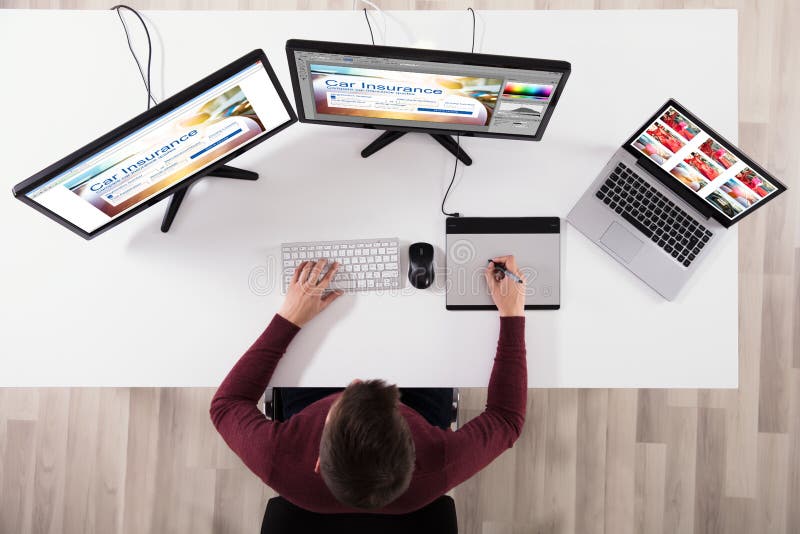 High Angle View Of Designer Making Web Page Design On Computer Using Graphic Tablet. High Angle View Of Designer Making Web Page Design On Computer Using Graphic Tablet