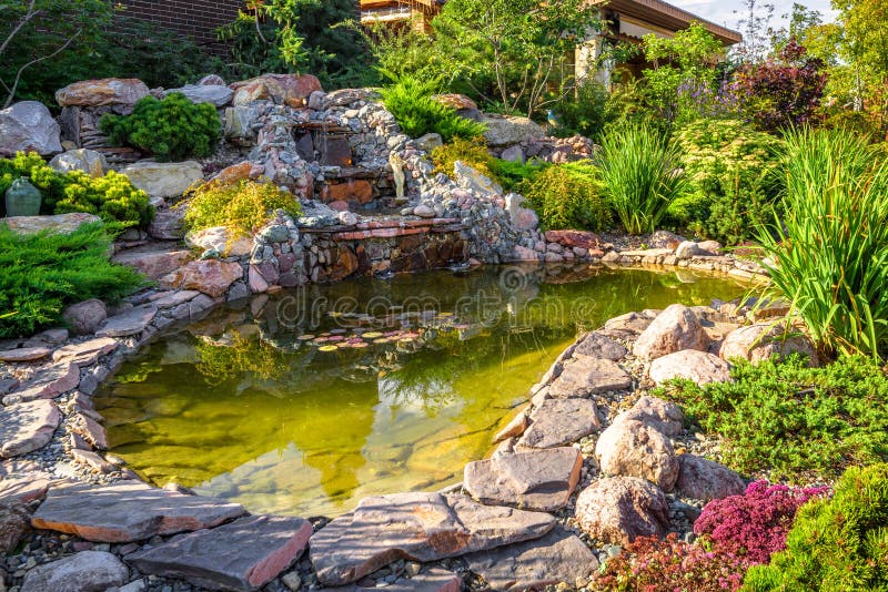 Diseño paisajístico de los jardines domésticos Hermoso paisaje con pequeño estanque y cascada fotografía de archivo libre de regalías