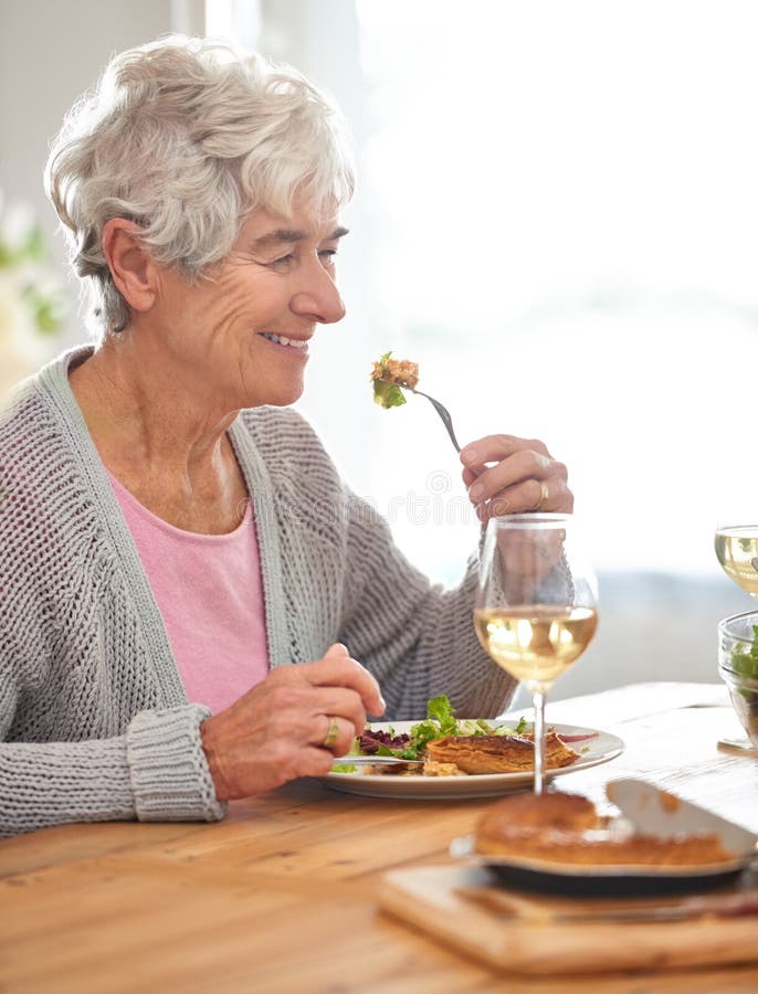 Disfrutar de las cosas simples en la vida. una anciana comiendo solo su almuerzo.