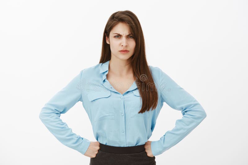 Disgrace for our company. Portrait of angry displeased bossy woman in blue blouse, holding hands on hips and frowning