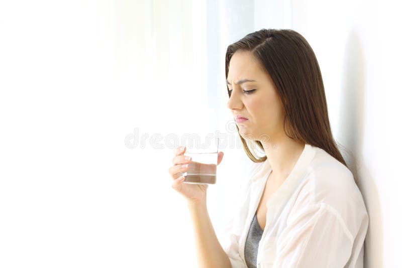 Disgusted woman drinking water with bad taste on white