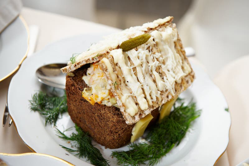 Dish of bread and salad in shape of house