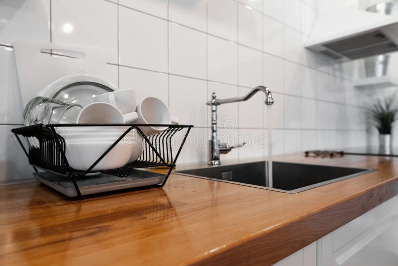 Dish Rack Holds Many Dishes and Cups Against Wooden Countertop, White Wall Tiles, Sink and Faucet. Budget and Lightweight Stock Image - Image of rack, crockery: 183605655