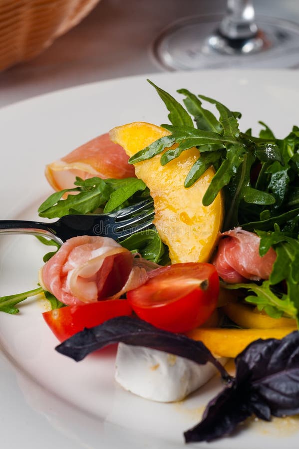 Dish in the Restaurant Fresh Salad with Basil, Prosciutto, Tomato and