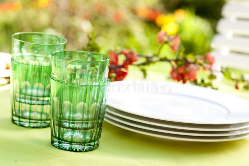 Bicchieri e piatti su un tavolo in giardino.