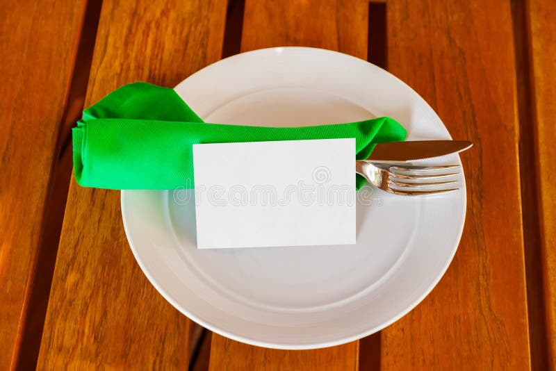 Dishware och tomt pappers- kort på tabellen i restaurang