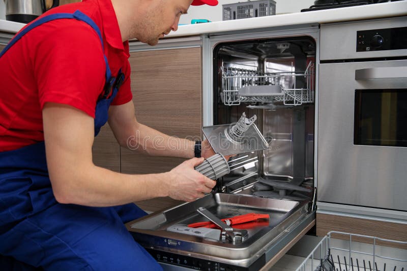 Dishwasher maintenance service - repairman checking food residue filters