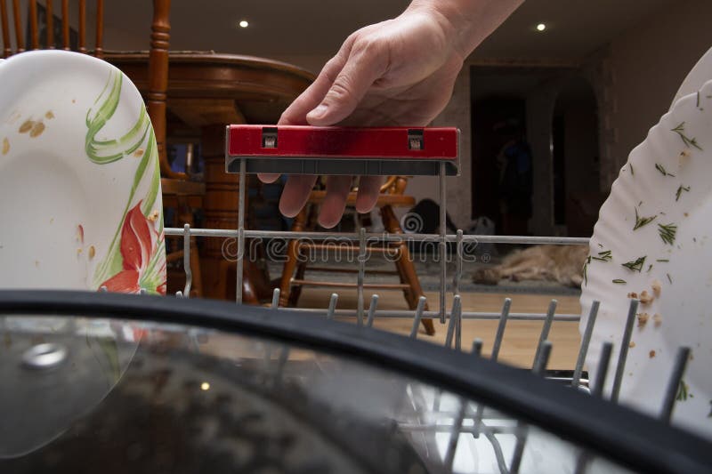 Dishwasher. a Man Puts Dirty Dishes in the Dishwasher Stock Image