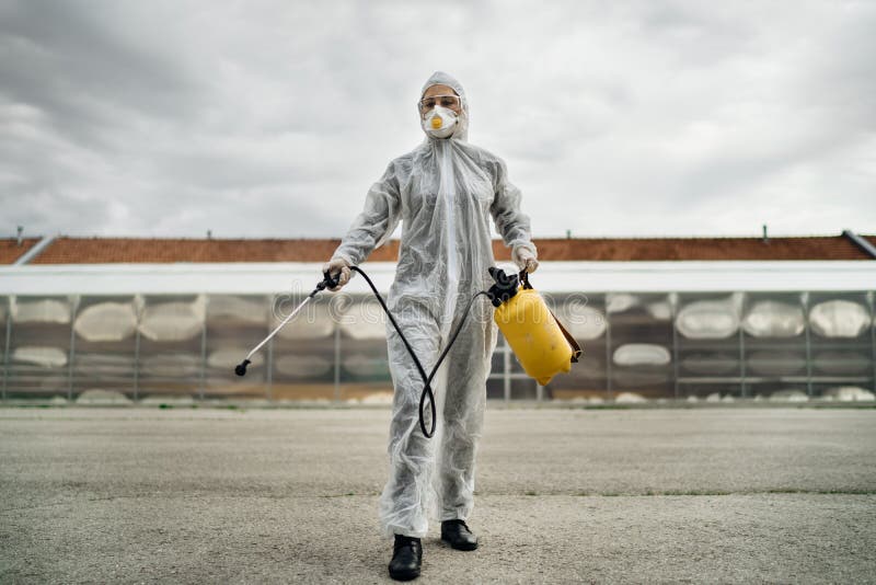 Disinfection specialist in private protective equipment PPE performing public decontamination.Hazmat suit virus protection. COVID-19 outbreak worker.Quarantined area.Dangerous hazard environment