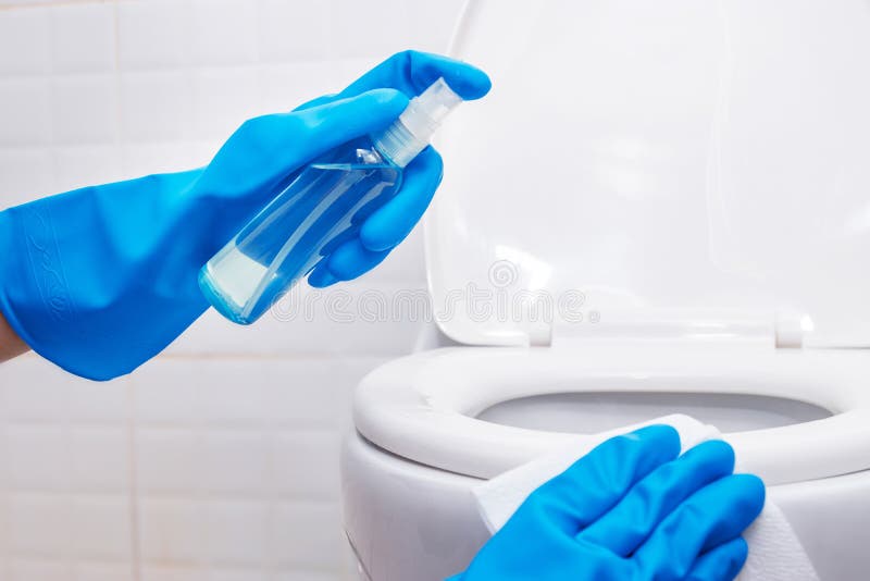 Disinfettare i servizi igienici. persone che utilizzano spray alcolici sul coperchio dei sedili della toilette e sull'area spesso