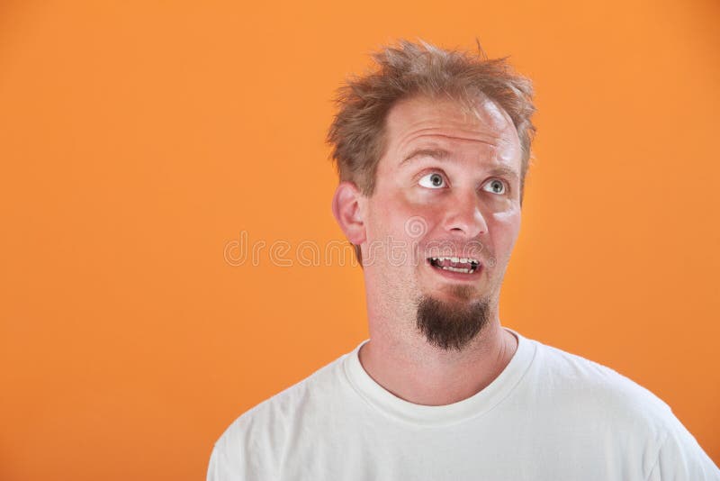 Disinterested Caucasian man with goatee on an orange background. Disinterested Caucasian man with goatee on an orange background