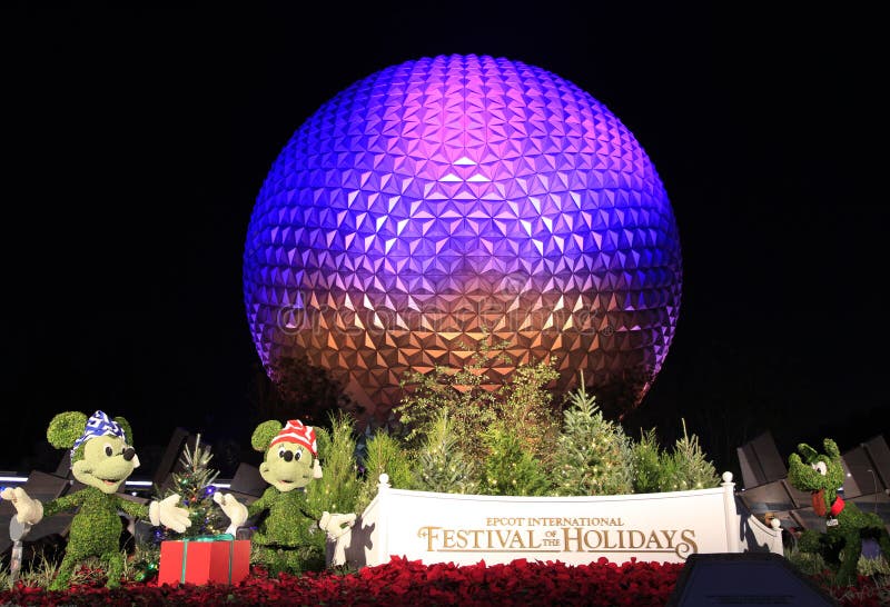 Disney ` s EPCOT centrum sfera iluminująca przy nocą podczas wakacje sezonu z Mickey Mouse, Minnie i Pluton charakterów trawą, sc