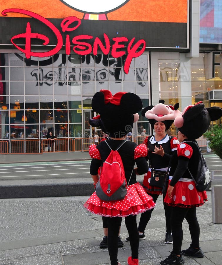 Disney store cu caractere minuscule pentru mouse. Câteva femei îmbrăcate în costum de șoarece minnie stând lângă magazinul de disney în Times Square din Manhattan.