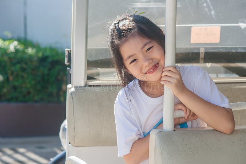 Dispare na situação bonito pequena asiática da menina no carro e no sorriso do golfe fotos de stock Dispare na situação bonito pequena asiática da menina no carro e no sorriso do golfe fotos de stock