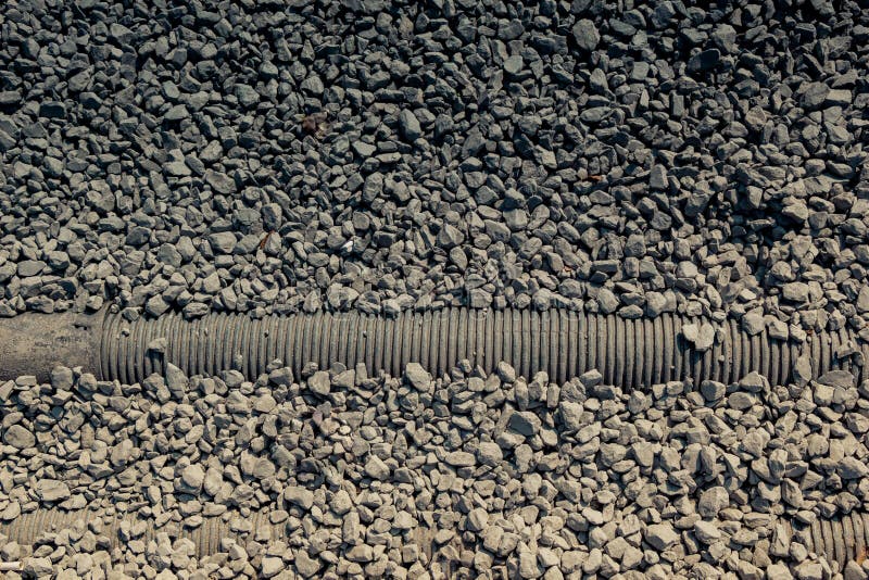 Disparo de gran angular de pequeñas piedras a lo largo de la tubería foto de archivo