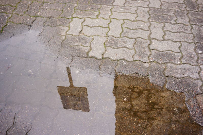 Disparo de gran angular de un pequeño charco en el suelo de adoquín foto de archivo