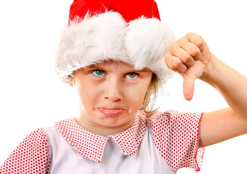 Displeased Little Girl in Santa Hat make Thumb Down on the White Background. Displeased Little Girl in Santa Hat make Thumb Down on the White Background