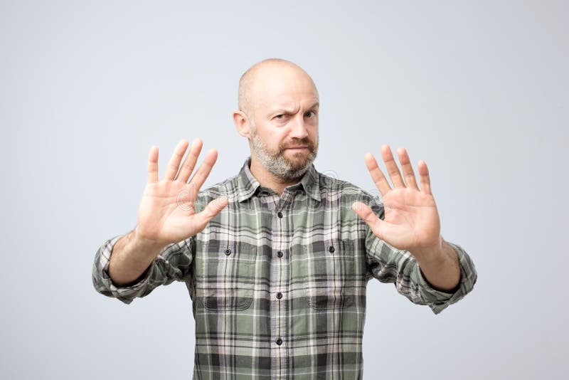 Displeased mature man refusing to accept the idea, stretching hands to camera stock photography Displeased mature man refusing to accept the idea, stretching hands to camera stock photography