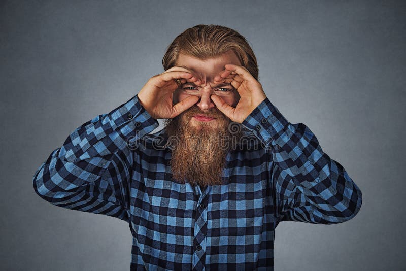Displeased young man looking through fingers like binoculars royalty free stock photos Displeased young man looking through fingers like binoculars royalty free stock photos