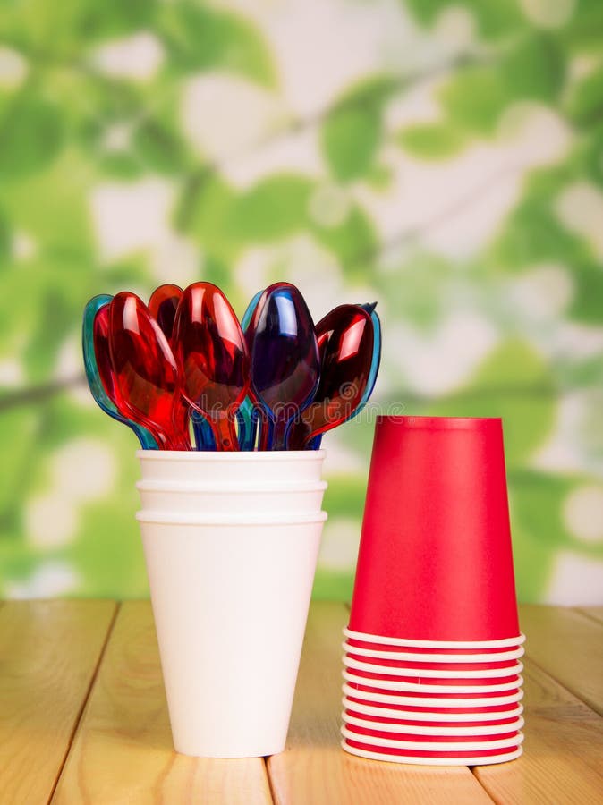 Disposable Paper Cups And Plastic Spoons On Bright Abstract Green