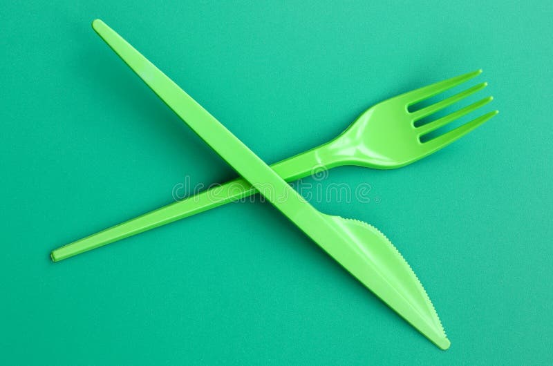 Disposable plastic cutlery green. Plastic fork and knife lie on