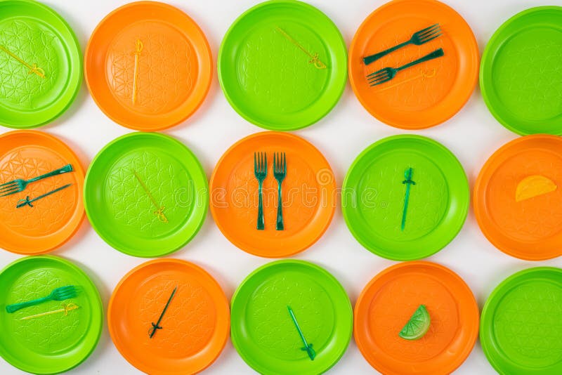 Disposable plastic utensils lying on bright plates stock photo