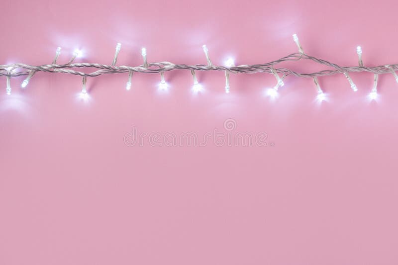 Disposition créative des lumières de Noël sur le fond rose image libre de droits Disposition créative des lumières de Noël sur le fond rose image libre de droits