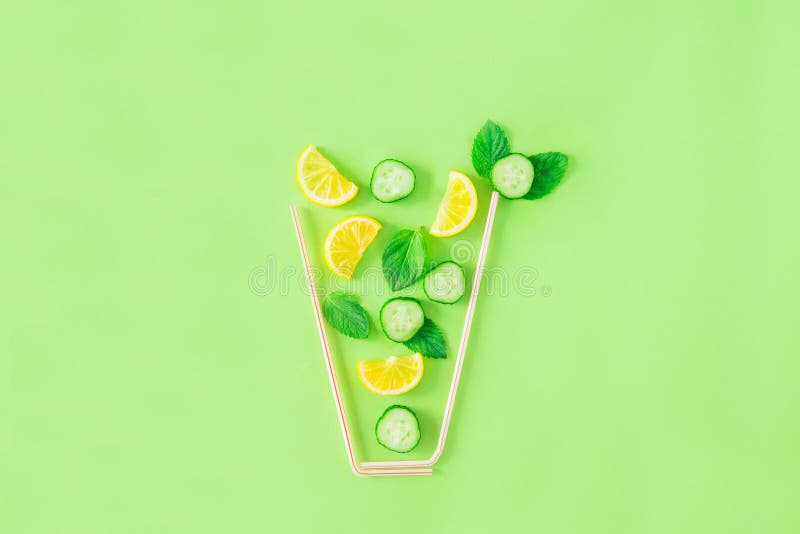 Disposizione creativa degli ingredienti della limonata - il limone, la menta, cetriolo affetta la caduta in vetro fatto con le pa immagine stock Disposizione creativa degli ingredienti della limonata - il limone, la menta, cetriolo affetta la caduta in vetro fatto con le pa immagine stock
