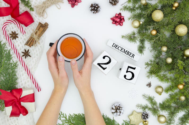 Disposizione piana degli ornamenti della decorazione di Natale sulla tazza bianca della tenuta della mano della donna e del fondo fotografia stock libera da diritti Disposizione piana degli ornamenti della decorazione di Natale sulla tazza bianca della tenuta della mano della donna e del fondo fotografia stock libera da diritti