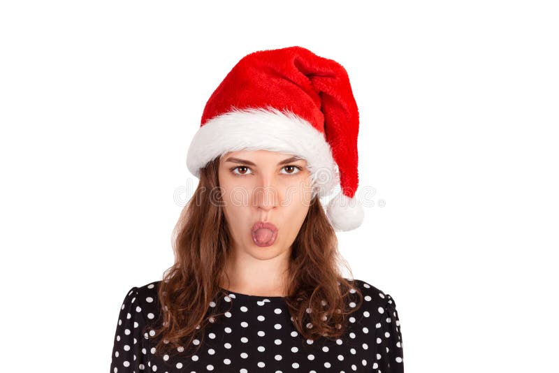 Dissatisfied brunette female model has disgusting expression, shows tongue, irritated with somebody. emotional girl in santa claus royalty free stock photo Dissatisfied brunette female model has disgusting expression, shows tongue, irritated with somebody. emotional girl in santa claus royalty free stock photo