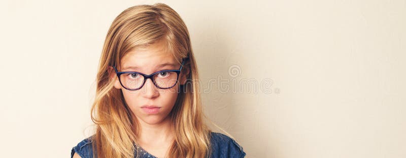 Dissatisfied teen girl looks suspiciously, sceptical, wearing glasses. Closeup portrait. stock image Dissatisfied teen girl looks suspiciously, sceptical, wearing glasses. Closeup portrait. stock image