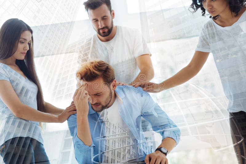 Dissatisfied young man being supported by his friends royalty free stock image Dissatisfied young man being supported by his friends royalty free stock image