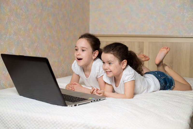 Distance learning online education. Schoolgirl and her sister studying at home with digital tablet laptop notebook stock photography Distance learning online education. Schoolgirl and her sister studying at home with digital tablet laptop notebook stock photography