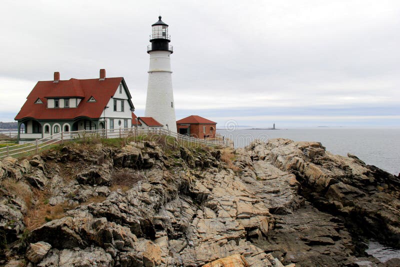 Distant view of Portland Head lighthouse, with stormy skies and rough seas, Maine,2016