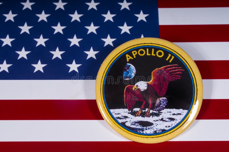 London, UK - November 15th 2018: The badge of the historic Apollo 11 moon landing, pictured over the flag of the United States of America. London, UK - November 15th 2018: The badge of the historic Apollo 11 moon landing, pictured over the flag of the United States of America