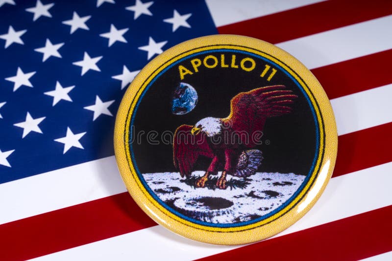 London, UK - November 15th 2018: The badge of the historic Apollo 11 moon landing, pictured over the flag of the United States of America. London, UK - November 15th 2018: The badge of the historic Apollo 11 moon landing, pictured over the flag of the United States of America