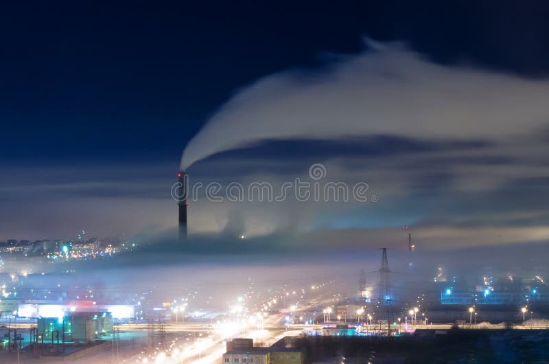 Distrito industrial de la ciudad, de los tubos y del humo, con niebla y niebla con humo en la noche foto de archivo libre de regalías Distrito industrial de la ciudad, de los tubos y del humo, con niebla y niebla con humo en la noche foto de archivo libre de regalías