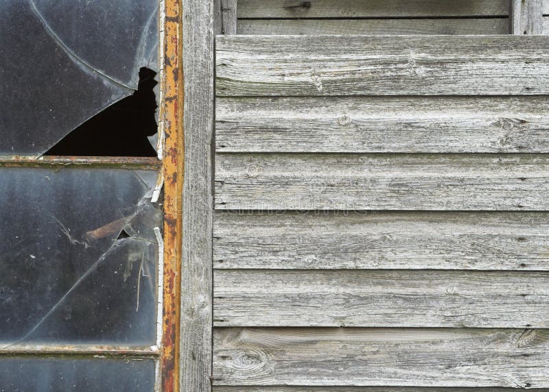 Detail of a neglected wooden outbuilding with broken windows. Detail of a neglected wooden outbuilding with broken windows.