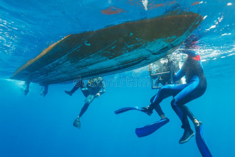 Divers Climbing into Boat stock photo. Image of boat - 61780338