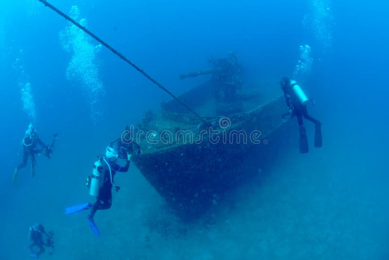 Divers exploring the ship wreck in tropical sea stock photography Divers exploring the ship wreck in tropical sea stock photography