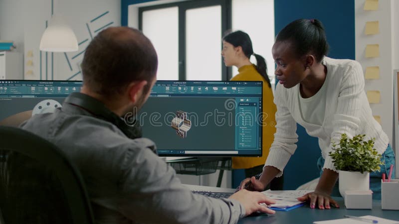 Divers ingénieurs travaillant à l'ordinateur à la conception de pièces mécaniques banque de vidéos
