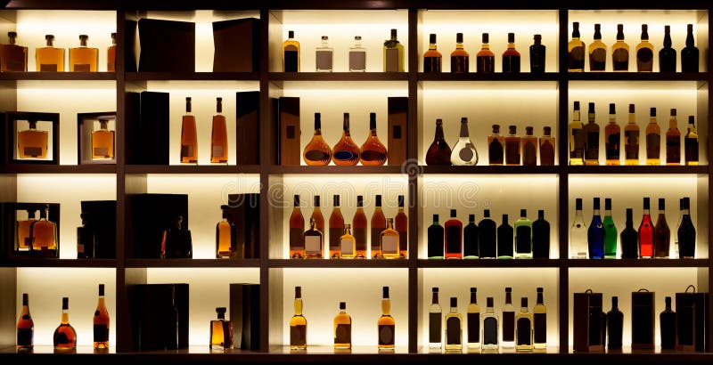 Various alcohol bottles in a bar, back light, all logos removed. Various alcohol bottles in a bar, back light, all logos removed