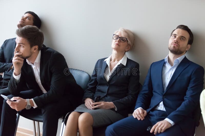 Diverse applicants getting bored in queue waiting for job interview royalty free stock photography Diverse applicants getting bored in queue waiting for job interview royalty free stock photography