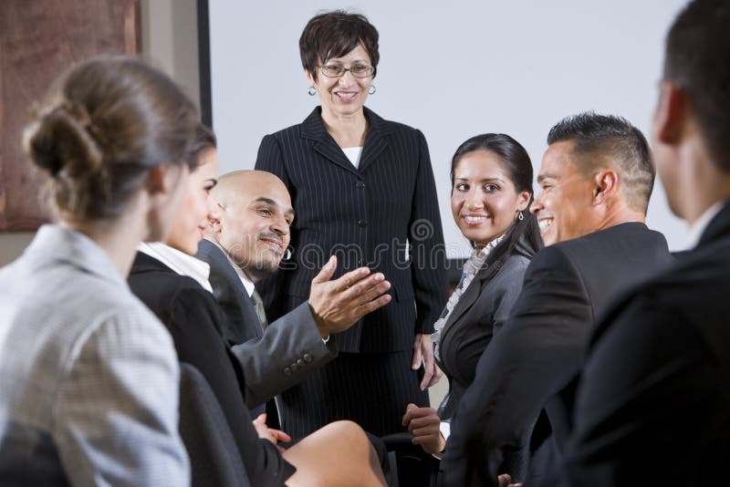 Diverse businesspeople die, vrouw bij voorzijde converseert Diverse businesspeople die, vrouw bij voorzijde converseert