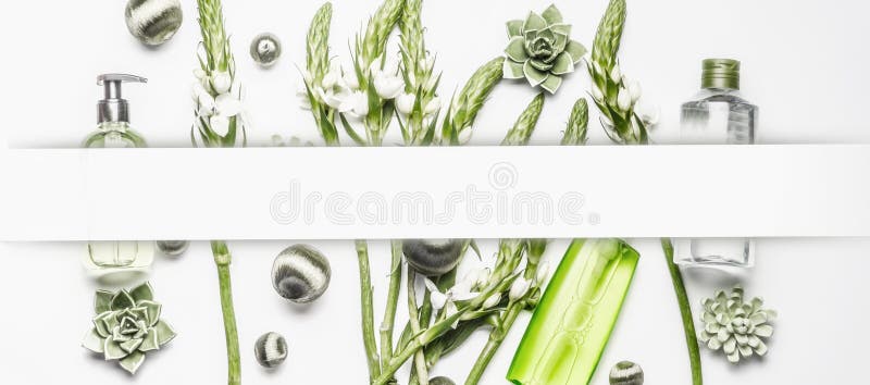 Diverse cosmetischee producten met groene bloemen en installaties op witte achtergrond, kader