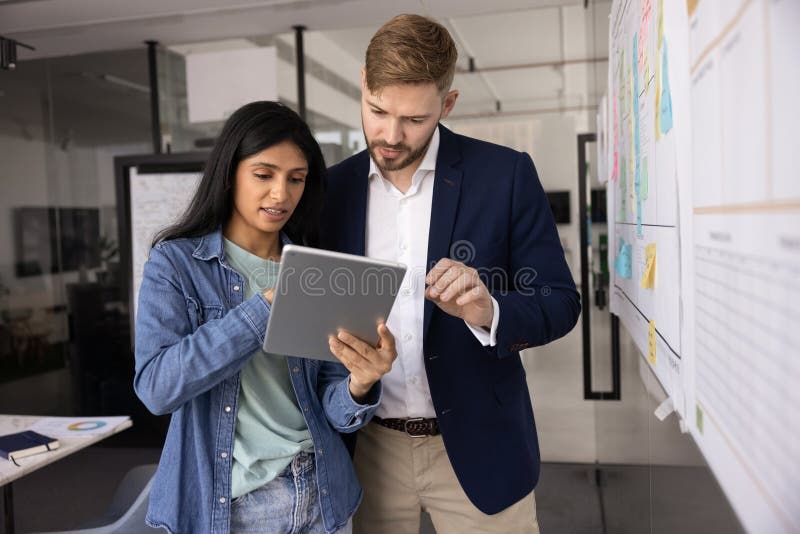 Diverse couple of young business colleagues using online application stock photo