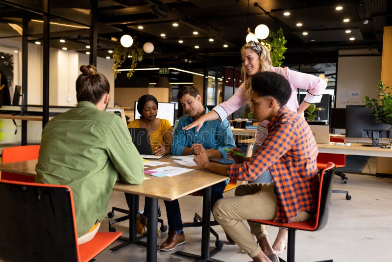 Diverse creative colleagues in discussion brainstorming using notes, tablet and laptop royalty free stock photography